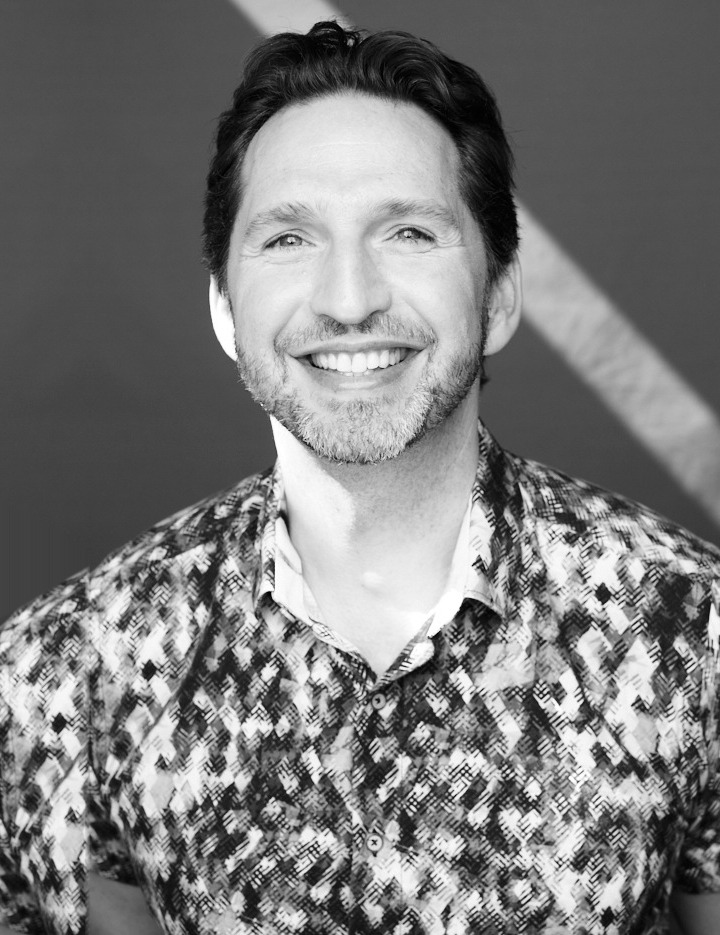 Noel Rosencranz smiling at the camera, in a black-and-white portrait