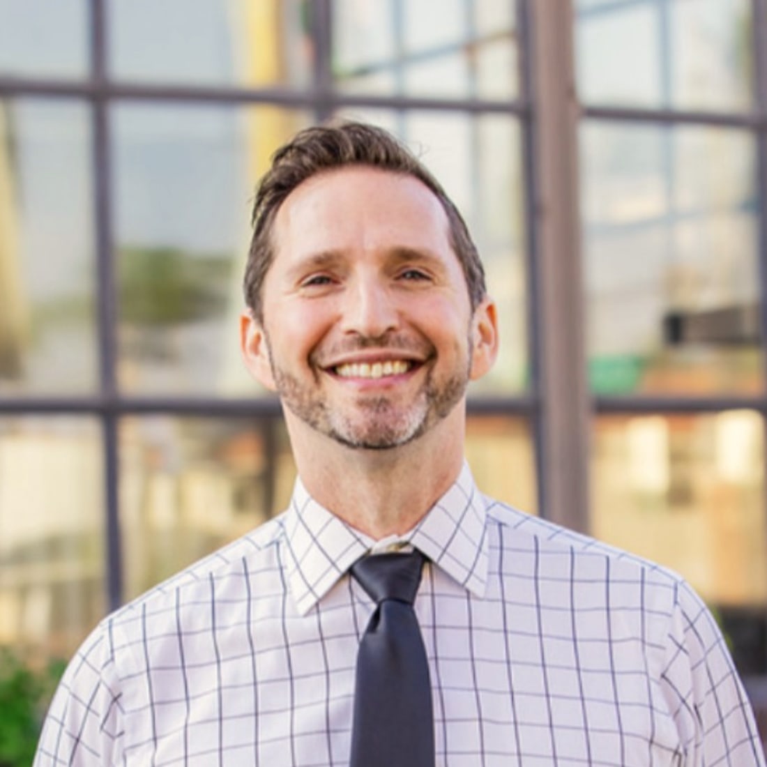 Noel Rosencranz, executive coach in Los Angeles, smiling outside a building in the city