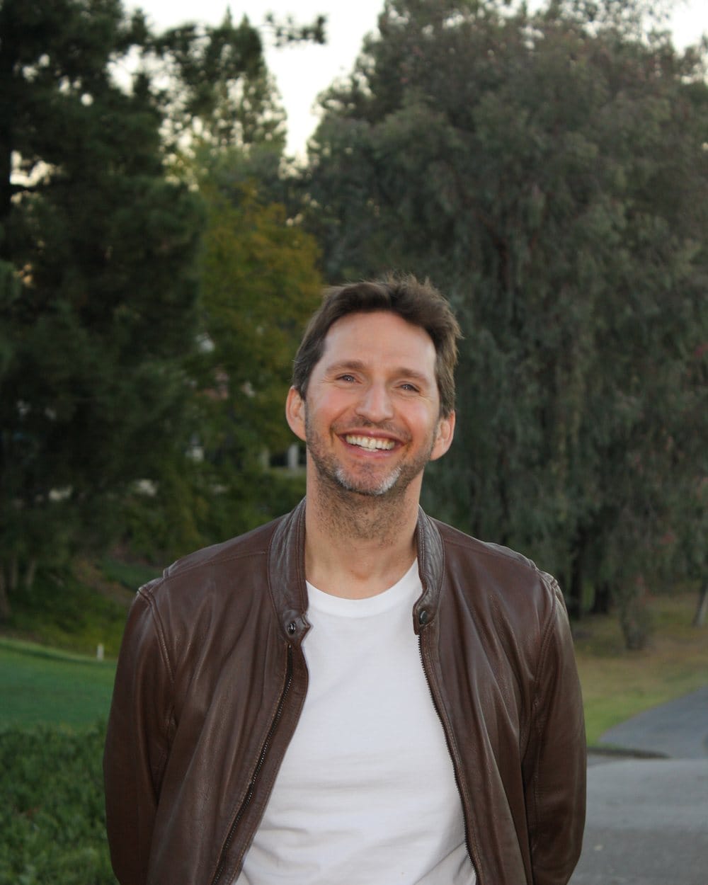 Noel Rosencranz, executive coach in Los Angeles, smiling outdoors in a leather jacket