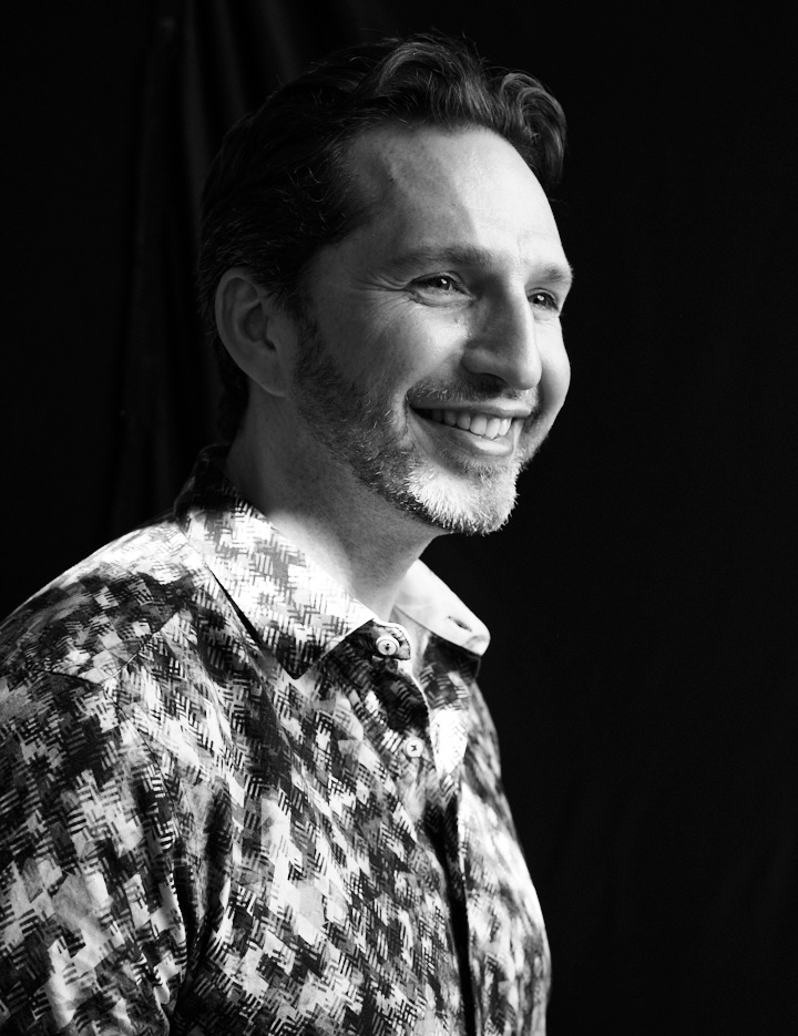 Noel Rosencranz smiling and looking off to the side, in a black-and-white portrait